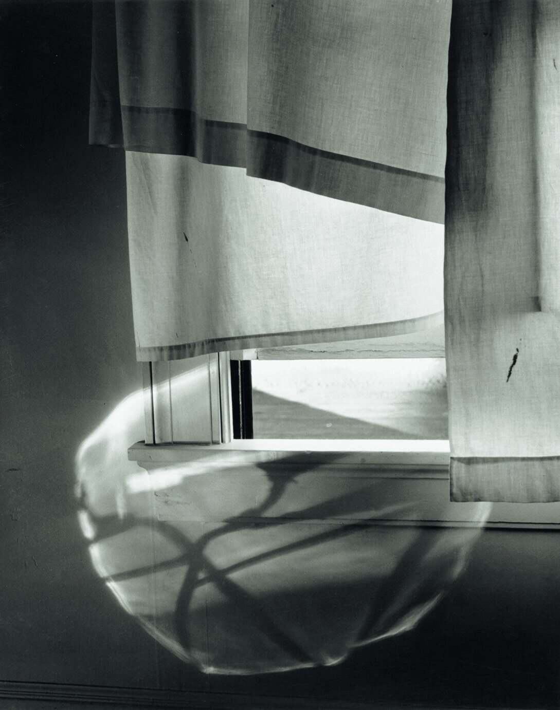 Cortina iluminada en una ventana de la calle Union Norte, Rochester, fotografiada por Minor White en 1958.